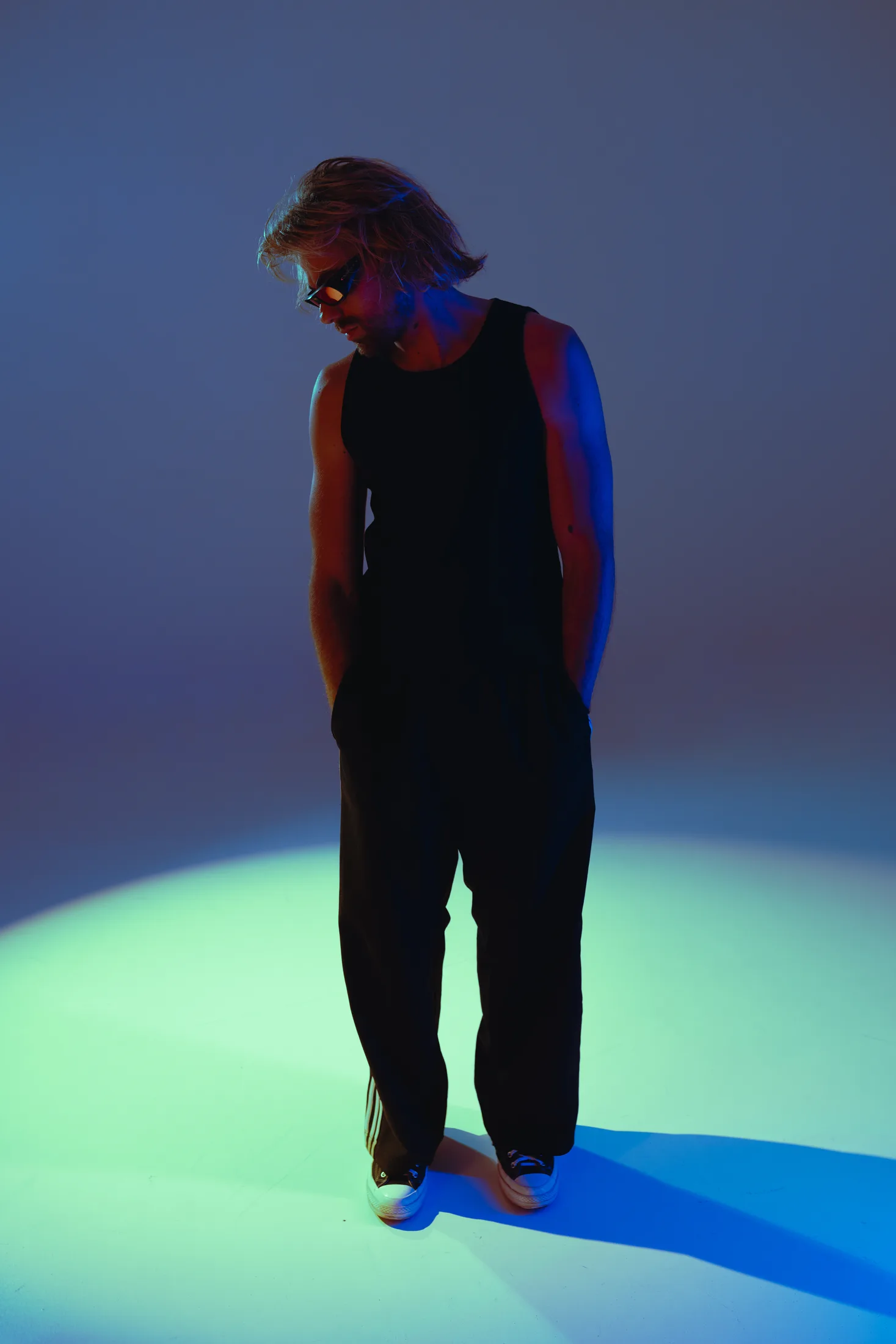 Goldcher standing in a blue and green spotlight