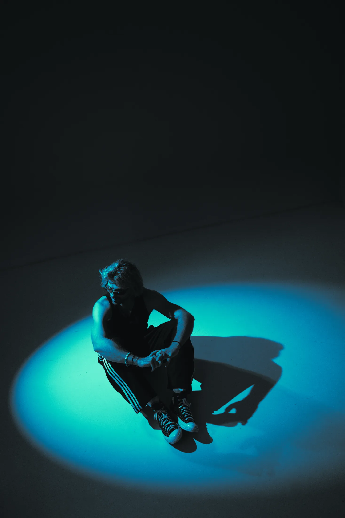 Goldcher seated under a blue spotlight